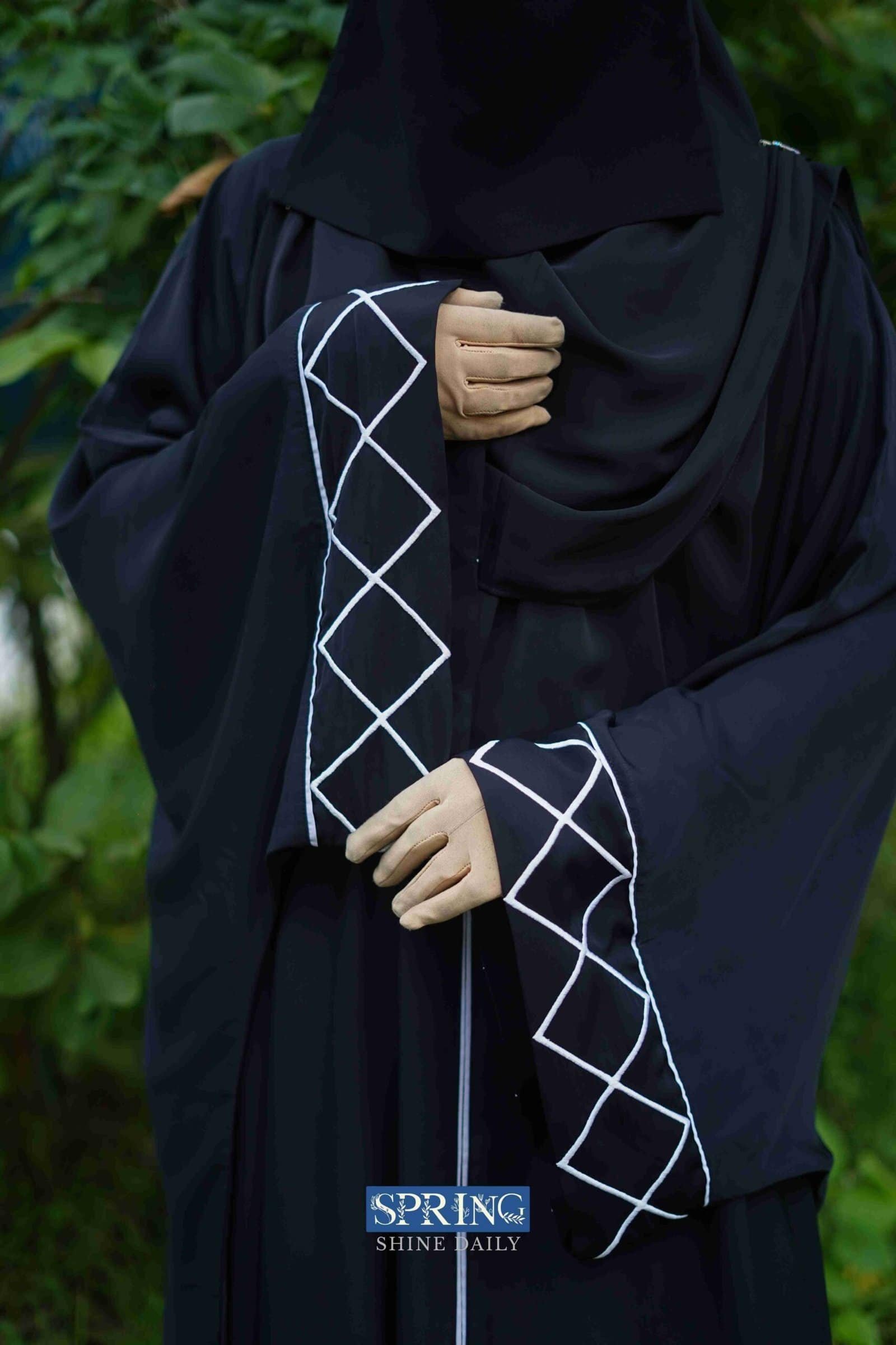 Elegant black abaya with white geometric embroidery, perfect for modest fashion and everyday wear.
